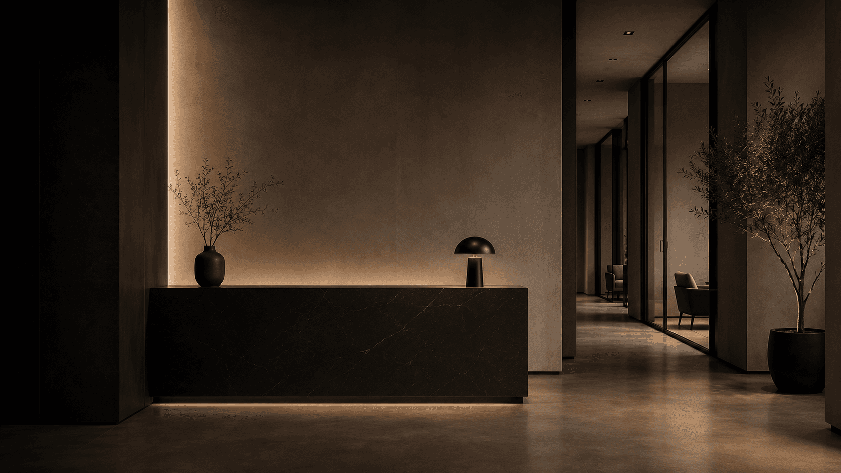 Interior minimalista com balcão de pedra escura, iluminação suave, luminária de mesa e plantas decorativas.